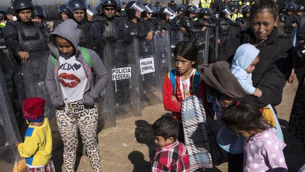 Migrantes contidos pela polícia mexicana na fronteira em Tijuana, México. - Sputnik Brasil