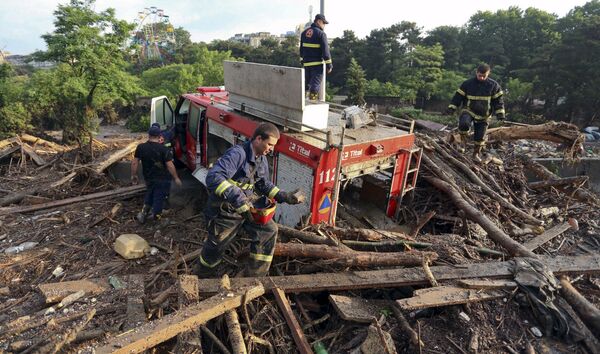 Uma equipe de bombeiros tenta lidar com correntes de água e lixo em uma rua alagada em Tbilisi - Sputnik Brasil