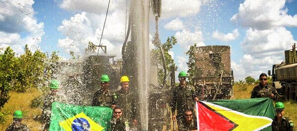 Militares brasileiros posam com bandeiras do Brasil e da Guiana diante de poço artesiano. - Sputnik Brasil