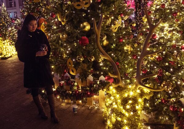 Turista em meio a decorações natalinas na praça Manezhnaya - Sputnik Brasil