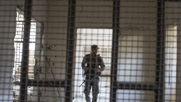 Um membro das Forças Democráticas da Síria (SDF) apoiadas pelos EUA caminha dentro de uma prisão construída por combatentes do Estado Islâmico. - Sputnik Brasil