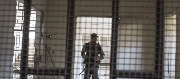 Um membro das Forças Democráticas da Síria (SDF) apoiadas pelos EUA caminha dentro de uma prisão construída por combatentes do Estado Islâmico. - Sputnik Brasil
