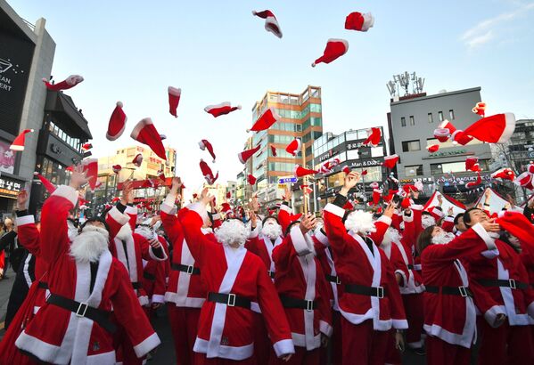 Papais Noéis sul-coreanos jogam gorros ao ar durante cerimônia de Natal, em Seul, Coreia do Sul, 24 de dezembro de 2018 - Sputnik Brasil