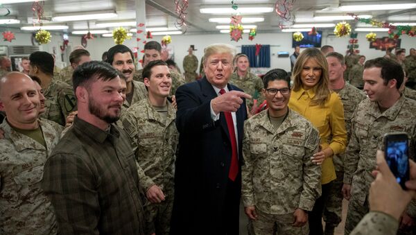 O presidente dos EUA, Donald Trump e a primeira-dama dos EUA, Melania Trump, posam para uma foto durante visita a membros do Exército dos EUA em um refeitório na base aérea de Al Asad. - Sputnik Brasil