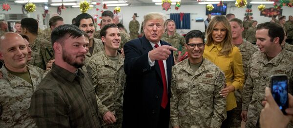 O presidente dos EUA, Donald Trump e a primeira-dama dos EUA, Melania Trump, posam para uma foto durante visita a membros do Exército dos EUA em um refeitório na base aérea de Al Asad. - Sputnik Brasil