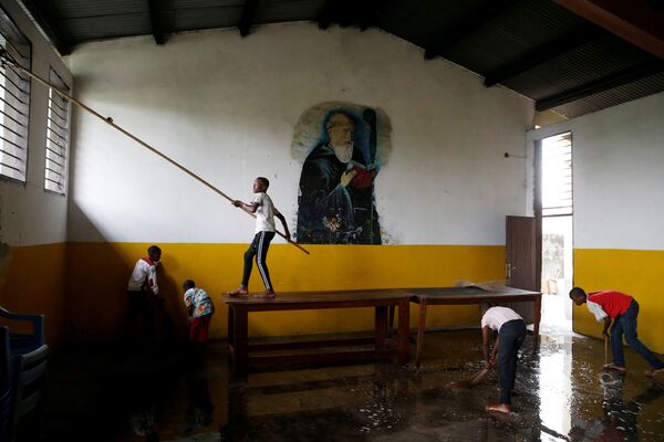 Garotos ajudam a limpar igreja de Saint-Benoît na preparação para o Natal, em Kinshasa - Sputnik Brasil