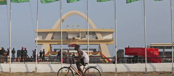 Homem andando de bicicleta ao lado de bandeiras de honra ao presidente de Gana, John Evans Atta Mills, na Praça da Independência em Acra, Gana, 9 agosto de 2012 (foto do arquivo) - Sputnik Brasil