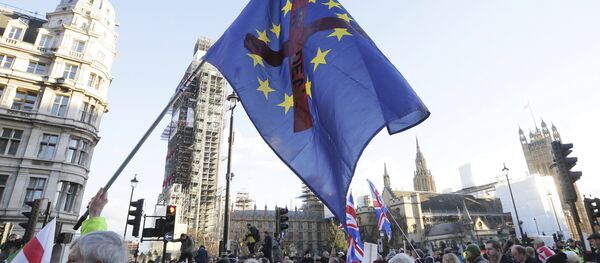 Manifestantes seguram cartazes e bandeiras na manifestação contra a Traição ao Brexit, em frente às Casas do Parlamento em Londres. - Sputnik Brasil