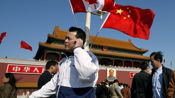 A man walks past flags of Canada and China in front of Tiananmen Gate in Beijing (File) - Sputnik Brasil