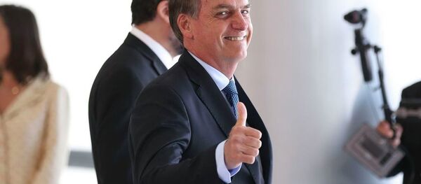 O presidente Jair Bolsonaro acena para os fotógrafos no Palácio do Planalto - Sputnik Brasil