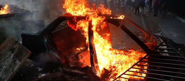 Carro em chamas durante protestos em Caracas, Venezuela - Sputnik Brasil
