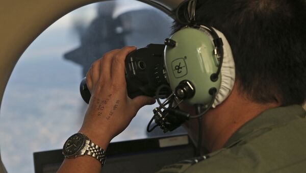 Oficial durante busca pelo avião do voo MH370, da companhia aérea Malaysia Airlines, no sul do oceano Índico, 22 de março de 2014 (imagem de arquivo) - Sputnik Brasil
