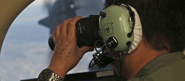 Oficial durante busca pelo avião do voo MH370, da companhia aérea Malaysia Airlines, no sul do oceano Índico, 22 de março de 2014 (imagem de arquivo) - Sputnik Brasil