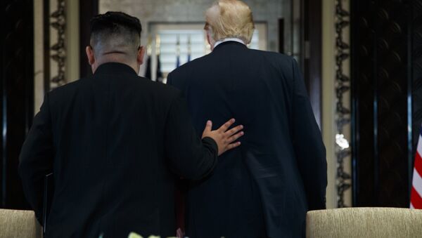 O presidente Donald Trump e o líder norte-coreano Kim Jong Um participante de uma cerimônia de assinatura durante uma reunião na ilha de Sentosa (arquivo) - Sputnik Brasil