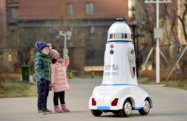 Crianças observam robô de segurança patrulhando complexo residencial na cidade de Hohhot, na China, 18 de janeiro de 2019 - Sputnik Brasil