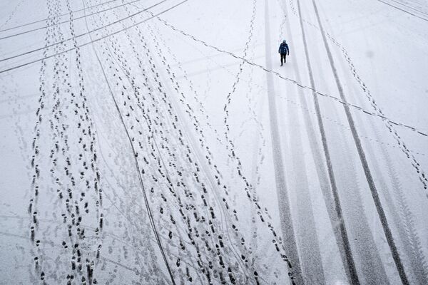 Transeunte durante queda de neve no Parque Gorky, em Moscou, Rússia - Sputnik Brasil