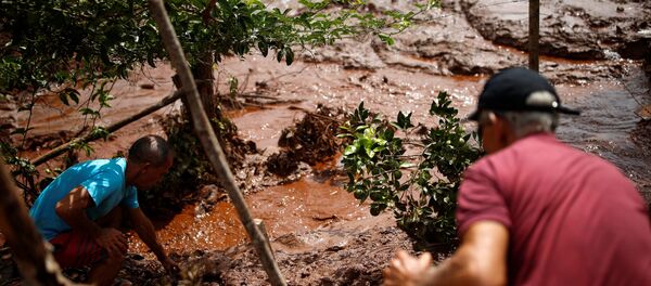 Moradores trabalham em um rio coberto por lama após uma barragem pertencente à mineradora brasileira Vale SA explodir em Brumadinho, Brasil, em 26 de janeiro de 2019. - Sputnik Brasil