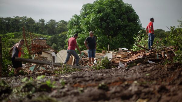 Moradores observam lama depois que uma barragem de propriedade da mineradora brasileira Vale SA explodiu, em Brumadinho - Sputnik Brasil