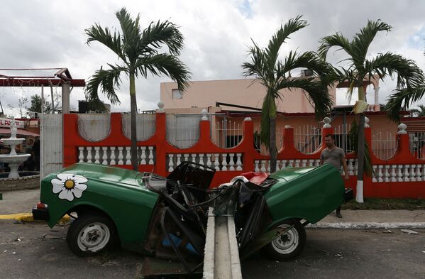 Homem olha para o carro esmagado pelo poste elétrico - Sputnik Brasil