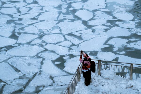 Garota tira foto do rio Chicago tomado pelo vórtice polar que atingiu a maioria dos estados norte-americanos ocidentais e centrais - Sputnik Brasil