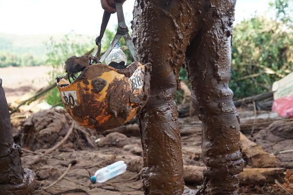 No detalhe, o capacete coberto de lama de uma oficial dos Bombeiros que trata na busca por corpos em Brumadinho, MG. - Sputnik Brasil