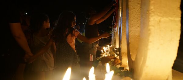 Uma criança é vista acendendo uma vela no letreiro de Brumadinho, local que se converteu em memorial em homenagem aos mortos pelo rompimento de barragem da Vale. - Sputnik Brasil