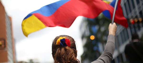 Uma manifestante venezuelana com a bandeira nacional - Sputnik Brasil