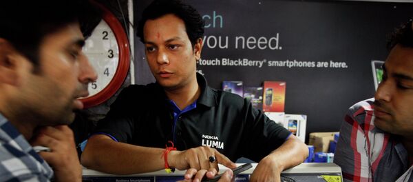 An Indian shopkeeper, center, tries to sell a Nokia mobile phone to a customer, left, in New Delhi, India - Sputnik Brasil