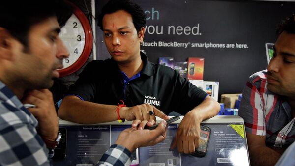 An Indian shopkeeper, center, tries to sell a Nokia mobile phone to a customer, left, in New Delhi, India - Sputnik Brasil