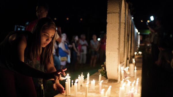 Mulher colocando velas em homenagem às vítimas em Brumadinho (MG). - Sputnik Brasil