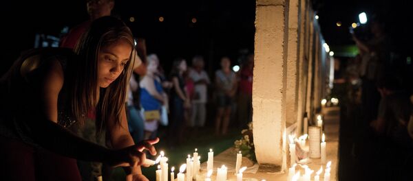 Mulher colocando velas em homenagem às vítimas em Brumadinho (MG). - Sputnik Brasil