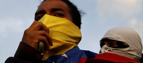 Manifestantes durante um protesto contra o governo do presidente venezuelano Nicolas Maduro em Caracas. - Sputnik Brasil
