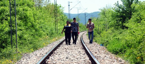 Refugiados seguem as trilhas de uma estrada de ferro perto da fronteira entre a Grécia e a Macedônia - Sputnik Brasil
