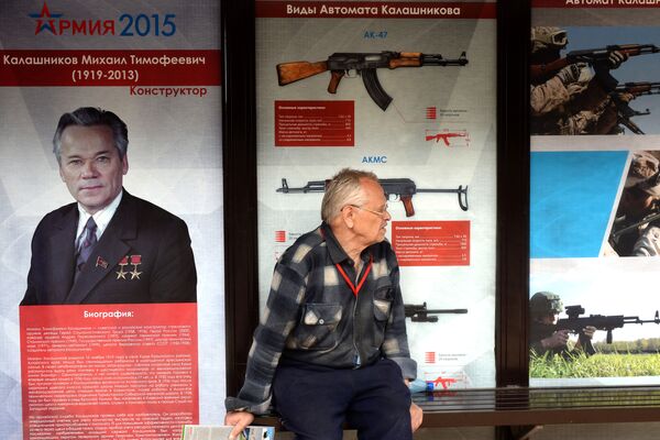 As imagens de fuzis do Consórcio Kalashnikov atras de um homem. - Sputnik Brasil