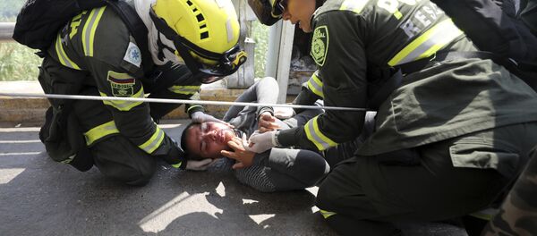 Paramédicos colombianos resgatam venezuelana ferida na Ponte Símon Bolívar, na fronteira entre Colômbia e Venezuela. - Sputnik Brasil