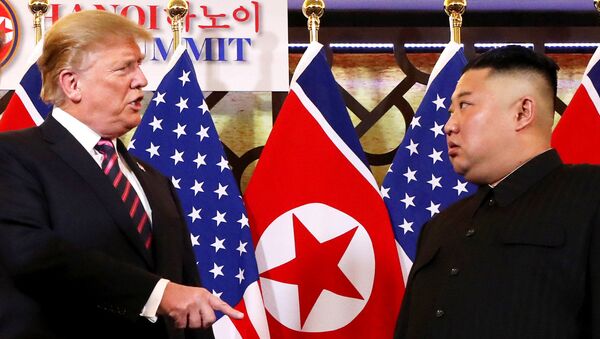 O presidente dos EUA Donald Trump fala com o líder norte-coreano Kim Jong-un depois de os dois líderes apertarem as mãos durante sua segunda reunião, em Hanói - Sputnik Brasil