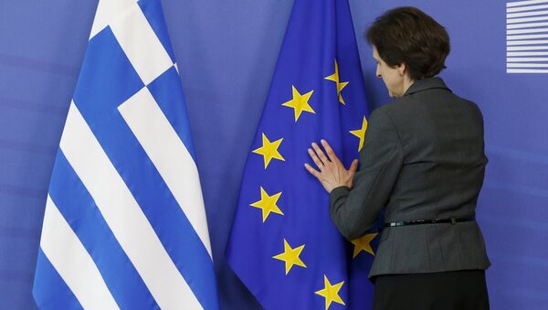 Funcionária arruma bandeiras da Grécia e da UE antes de encontro que aconteceu em Bruxelas entre o premiê grego Alexis Tsipras e o presidente da Comissão Europeia, Jean-Claude Juncker, em 3 de junho de 2015 - Sputnik Brasil