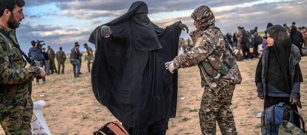 Membro das Forças Democráticas da Síria (SDF), lideradas por curdos, revista mulher em Baghouz, no norte da Síria, em 27 de fevereiro de 2019 - Sputnik Brasil