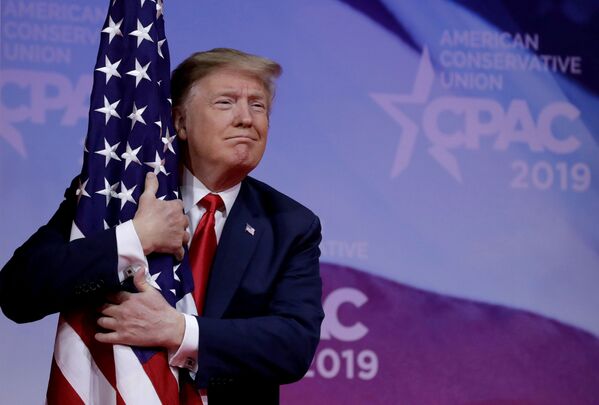 Presidente dos EUA, Donald Trump, abraça bandeira americana na reunião anual da Conferência da Ação Política Conservadora (CPAC), perto de Washington, EUA, em 2 de março de 2019. - Sputnik Brasil