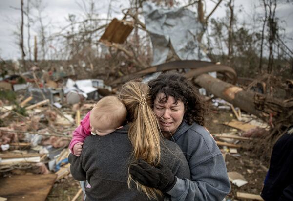 Família chorando nas ruínas de uma casa destruída pelo tornado, no estado norte-americano do Alabama - Sputnik Brasil