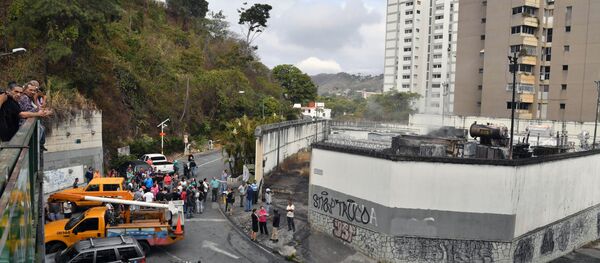 Moradores de Caracas reunidos do lado de fora de uma subestação de energia danificada da estatal Corpoelec, na capital do país, onde explosões de causa desconhecida ocorreram neste 11 de março de 2019, dias após o início de um grande apagão elétrico que segue afetando várias áreas da Venezuela. - Sputnik Brasil