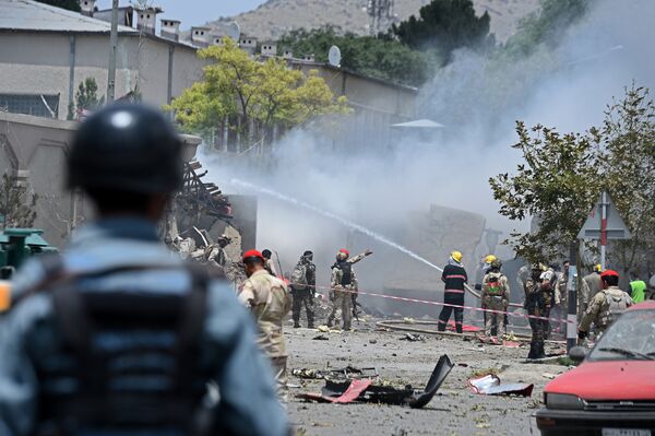 Policial afegão observa resgatistas trabalhando no local de uma explosão no parlamento em Cabul - Sputnik Brasil