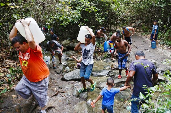 Pessoas enchem garrafas e outros recipientes com água do monte Ávila, nos arredores de Caracas - Sputnik Brasil