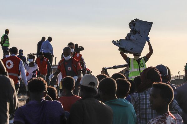 Homem leva um destroço do avião da companhia aérea Ethiopian Airlines que caiu perto da cidade etíope de Bishoftu, em 10 de março de 2019 - Sputnik Brasil