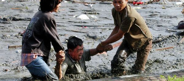 Acehnese youths try to pull a man to higher ground through a flooded street a moment after tsunami strike in the provincial capital of Banda Aceh, Aceh province, Indonesia - Sputnik Brasil