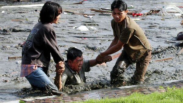 Acehnese youths try to pull a man to higher ground through a flooded street a moment after tsunami strike in the provincial capital of Banda Aceh, Aceh province, Indonesia - Sputnik Brasil