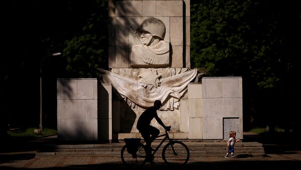 Um homem anda de bicicleta em frente ao monumento da Gratidão pelos soldados do exército soviético em Varsóvia, na Polônia. - Sputnik Brasil