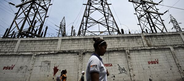 Uma mulher caminha em frente a postes de eletricidade em Caracas, Venezuela (Arquivo) - Sputnik Brasil