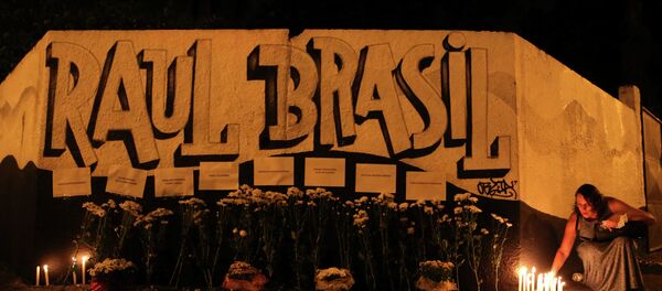 Mulher coloca vela em frente a Escola Estadual Raul Brasil, em Suzano, Grande São Paulo, palco do atentado que deixou 10 pessoas mortas - Sputnik Brasil