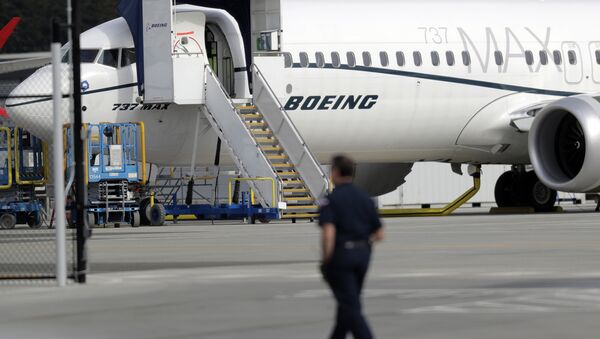 Um trabalhador caminha ao lado de um avião Boeing 737 MAX 8 estacionado. - Sputnik Brasil